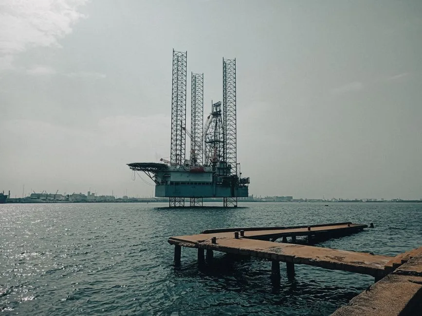 Offshore oil platform in urban harbor, showcasing industrial scenery and oceanic platform structure.